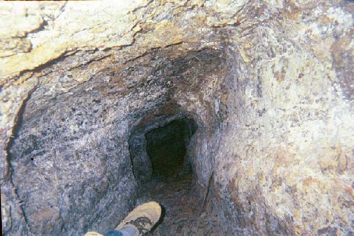 The first section of the new passage. I was almost laying down, since the passage was so small. My feet are extended in front of me, as you can see. Notice the broken rock on the floor of the cave. The passage looks like a dead-end, but it turns gently to the right near the end.